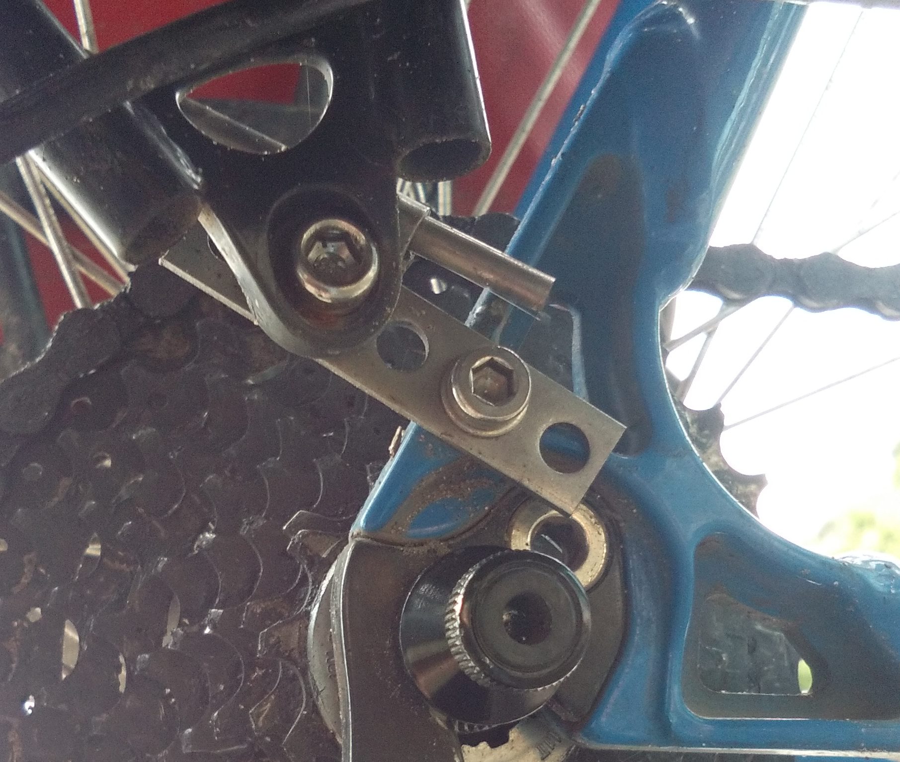 The use the disc brake mounting hole on the other side and this little piece of metal to make the other side the same length.